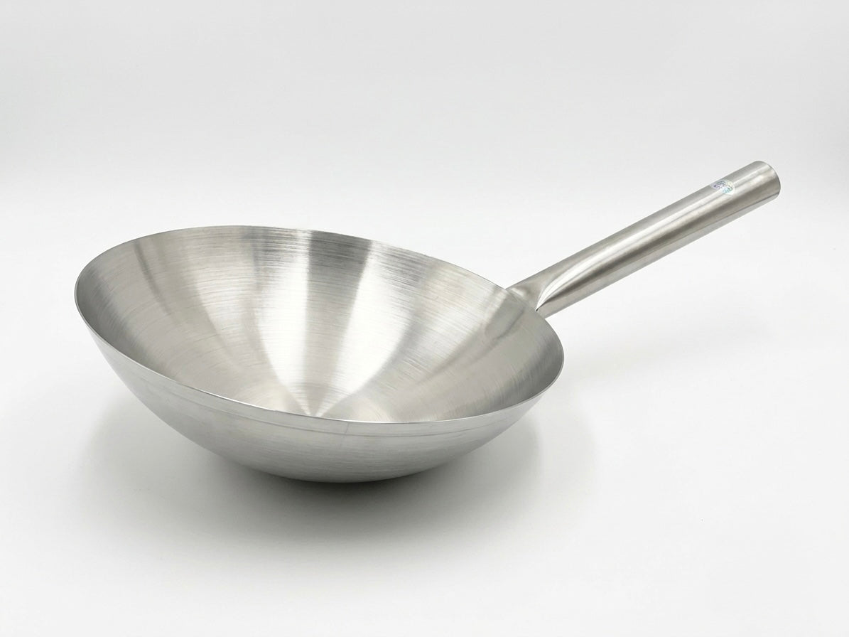 A stainless steel wok with a brushed metal finish and a long handle, shown on a clean white background.